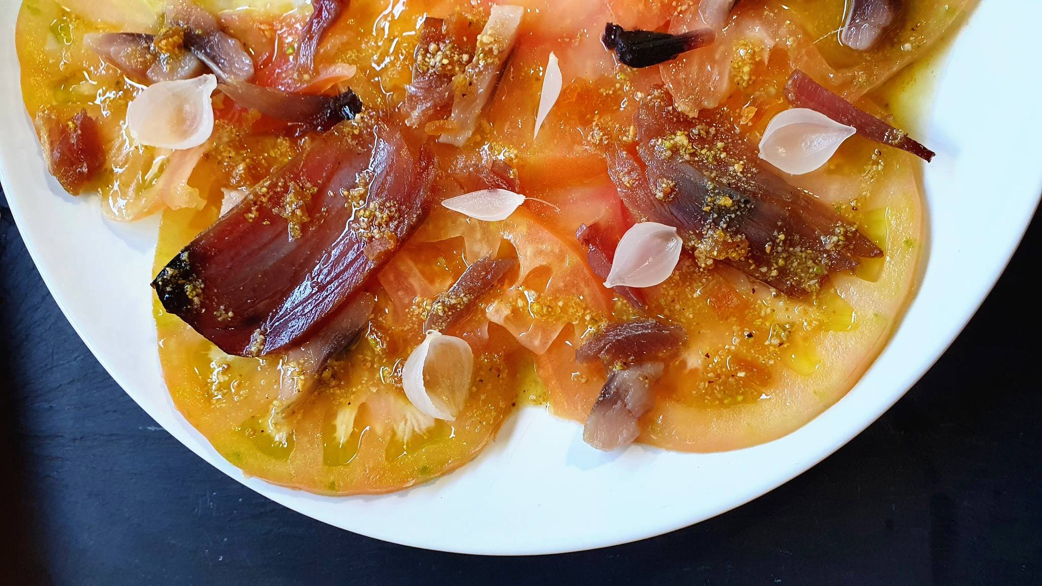 CARPACCIO DE TOMATE DEL PERELLÓ CON SALAZONES, ENCURTIDOS Y VINAGRETA DE FRUTOS SECOS.